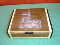 Caja de madera con un castillo de plata en la tapa